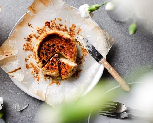 Vue de dessus d'un mini gâteau au fromage basque sur une assiette avec deux morceaux découpés
