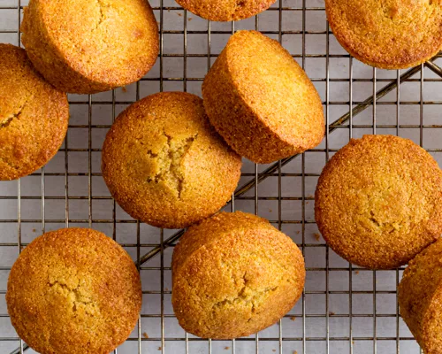 Muffins à la semoule de maïs sur une grille de refroidissement avec un tissu vert pâle