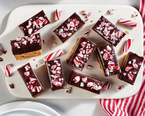 Barres de pâte à biscuits recouvertes d’une ganache au chocolat assortie de morceaux de bonbons à la menthe sur un plateau