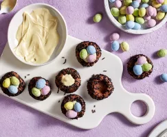 Sept biscuits au chocolat en forme de nid d'oiseau garnis de chocolat blanc et d'œufs en chocolat enrobés de bonbons