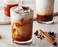 Verre d'infusion froide aux épices de citrouille avec un bâton de cannelle et clou de girofle 